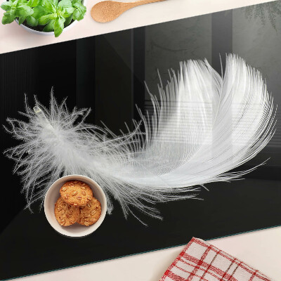 Glass chopping board Feather on a black background