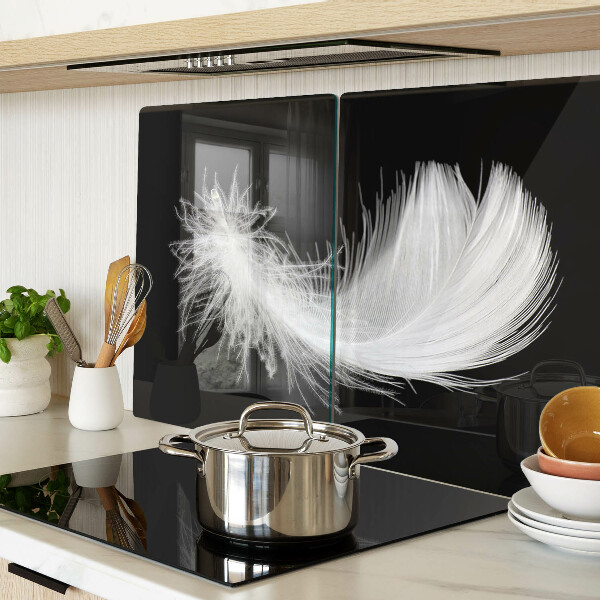 Glass chopping board Feather on a black background
