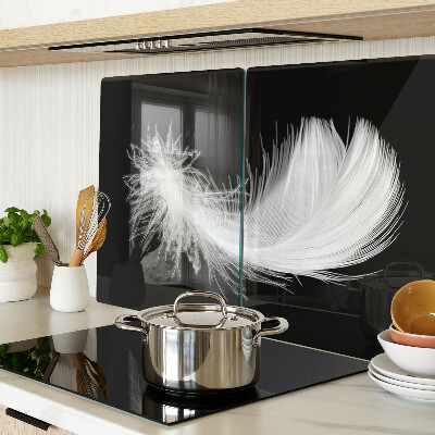 Glass chopping board Feather on a black background