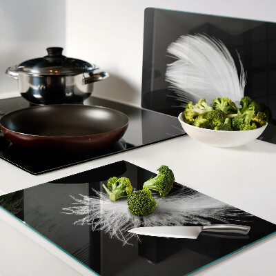 Glass chopping board Feather on a black background