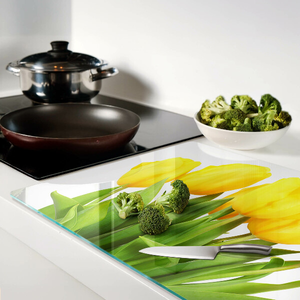 Glass kitchen board Yellow tulips on a green background