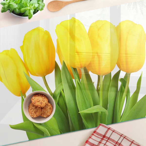 Glass kitchen board Yellow tulips on a green background