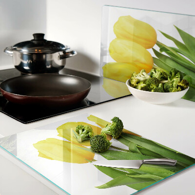 Glass kitchen board Yellow tulips on a green background
