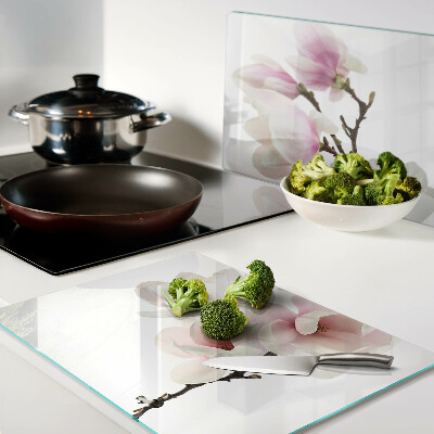 Chopping board glass Magnolia flowers on a branch