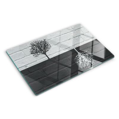 Glass chopping board A tree against a background of bricks