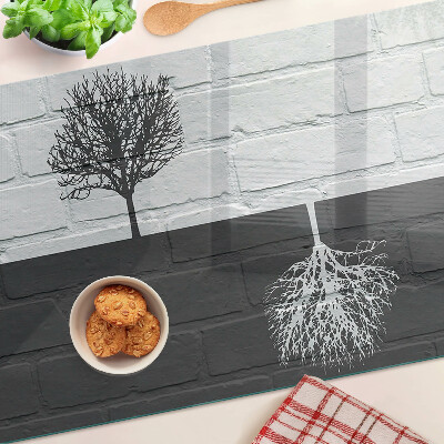 Glass chopping board A tree against a background of bricks