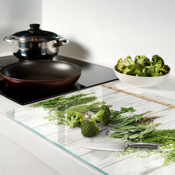 Chopping board glass Herbs on a wooden background