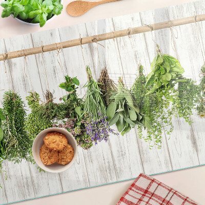 Chopping board glass Herbs on a wooden background