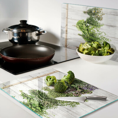 Chopping board glass Herbs on a wooden background