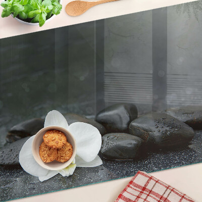 Glass kitchen board Orchid flower on stones
