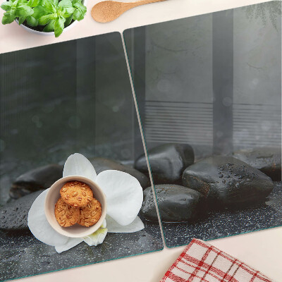 Glass kitchen board Orchid flower on stones