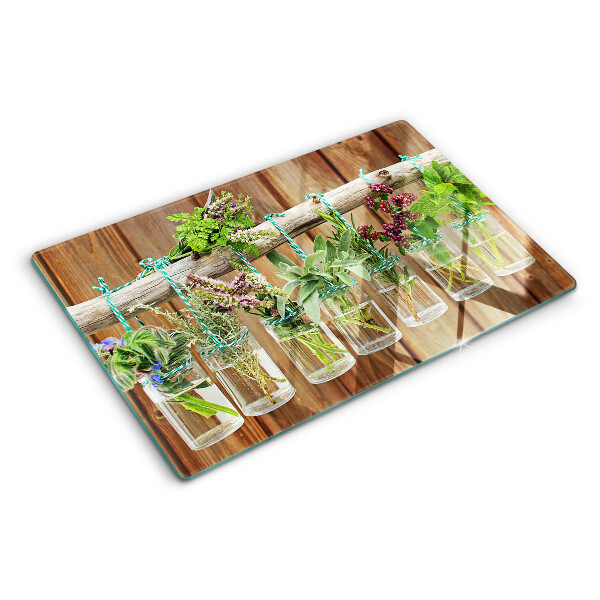 Glass chopping board Herbs in jars on a wooden background