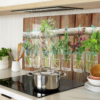 Glass chopping board Herbs in jars on a wooden background