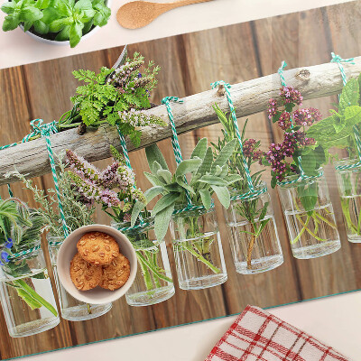 Glass chopping board Herbs in jars on a wooden background