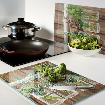Glass chopping board Herbs in jars on a wooden background