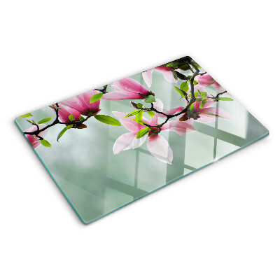 Glass kitchen board Magnolia flowers against a background of greenery