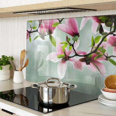 Glass kitchen board Magnolia flowers against a background of greenery