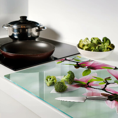 Glass kitchen board Magnolia flowers against a background of greenery