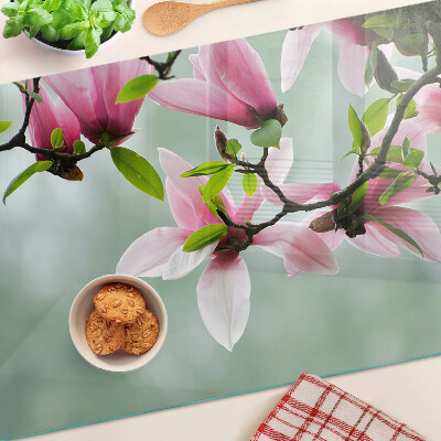 Glass kitchen board Magnolia flowers against a background of greenery