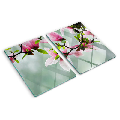 Glass kitchen board Magnolia flowers against a background of greenery