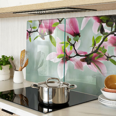 Glass kitchen board Magnolia flowers against a background of greenery