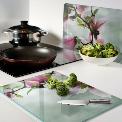 Glass kitchen board Magnolia flowers against a background of greenery