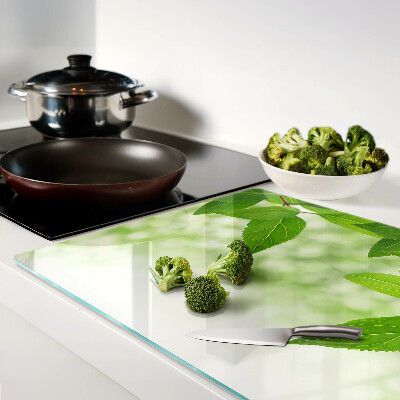 Chopping board glass Leaves against a background of blurred greenery