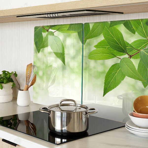 Chopping board glass Leaves against a background of blurred greenery