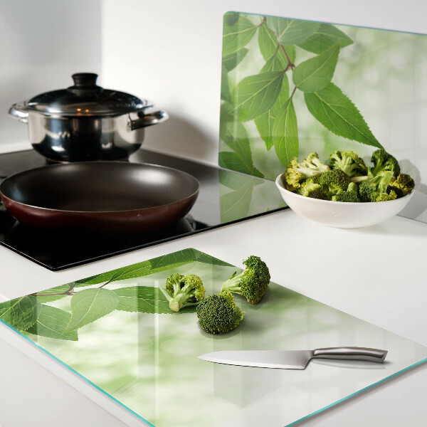 Chopping board glass Leaves against a background of blurred greenery