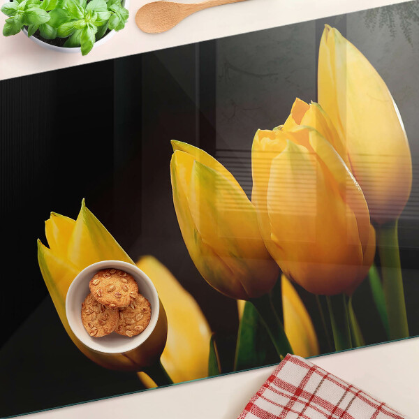 Glass kitchen board Yellow tulips on a black background