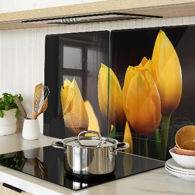 Glass kitchen board Yellow tulips on a black background
