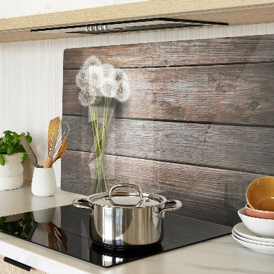 Glass chopping board Dandelion flowers on a wooden background