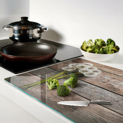 Glass chopping board Dandelion flowers on a wooden background