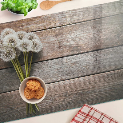 Glass chopping board Dandelion flowers on a wooden background