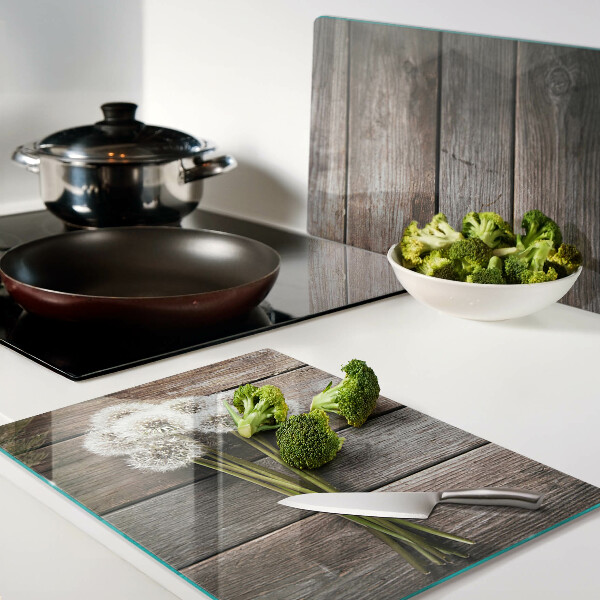 Glass chopping board Dandelion flowers on a wooden background