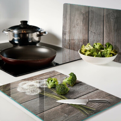 Glass chopping board Dandelion flowers on a wooden background