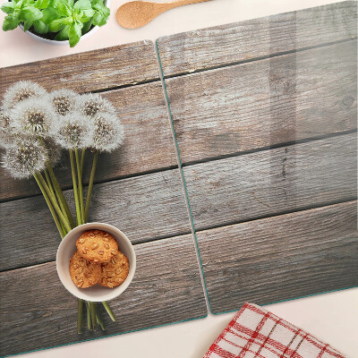 Glass chopping board Dandelion flowers on a wooden background