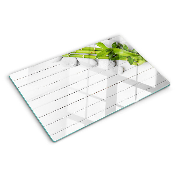 Glass chopping board Bamboo and stones on a wood background