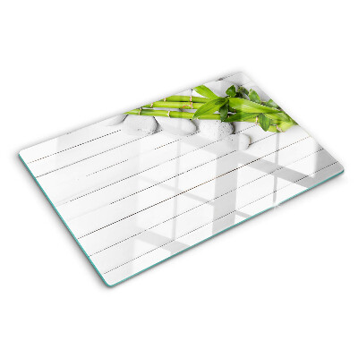 Glass chopping board Bamboo and stones on a wood background