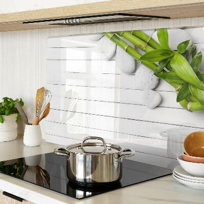 Glass chopping board Bamboo and stones on a wood background