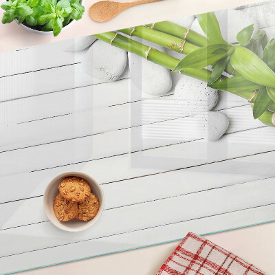Glass chopping board Bamboo and stones on a wood background