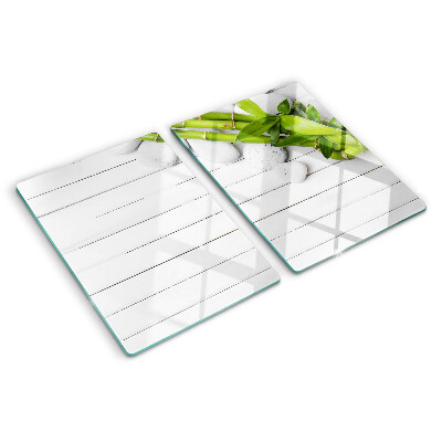 Glass chopping board Bamboo and stones on a wood background