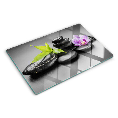 Glass chopping board Stones and orchid on the background