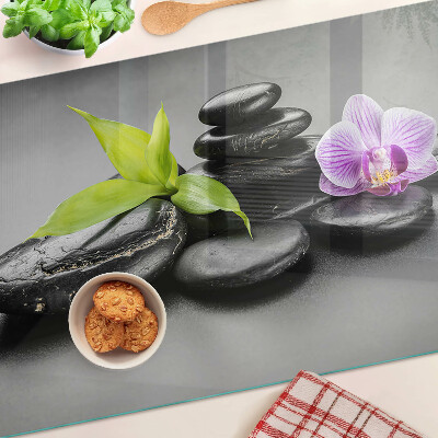 Glass chopping board Stones and orchid on the background