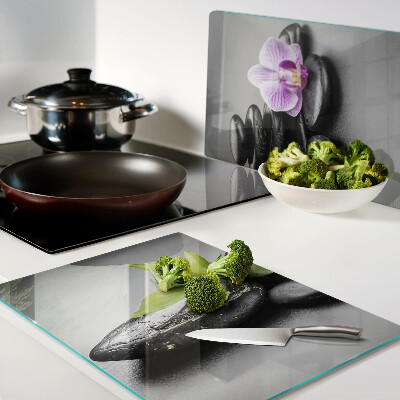 Glass chopping board Stones and orchid on the background