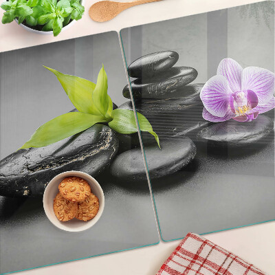 Glass chopping board Stones and orchid on the background