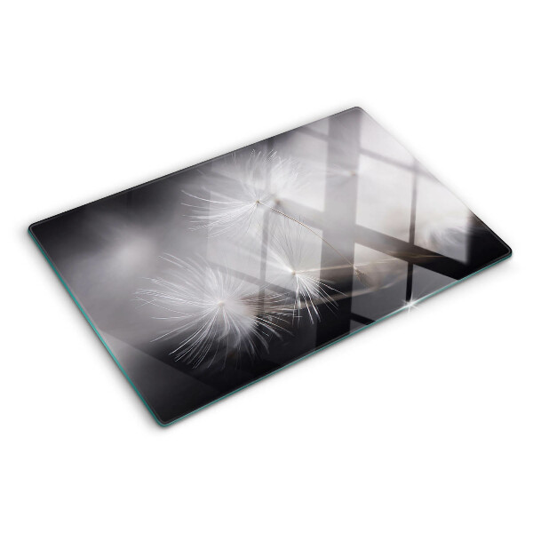 Glass chopping board Fluffy dandelions against the window background