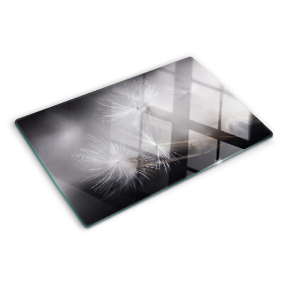 Glass chopping board Fluffy dandelions against the window background