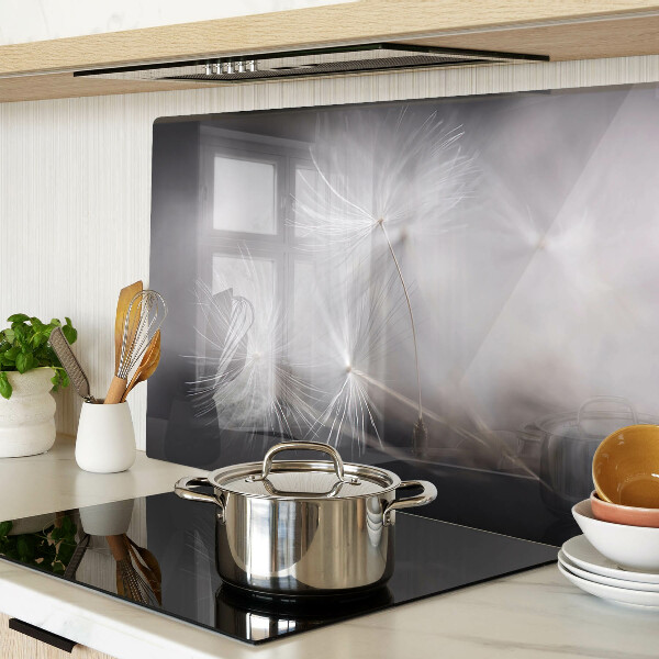 Glass chopping board Fluffy dandelions against the window background