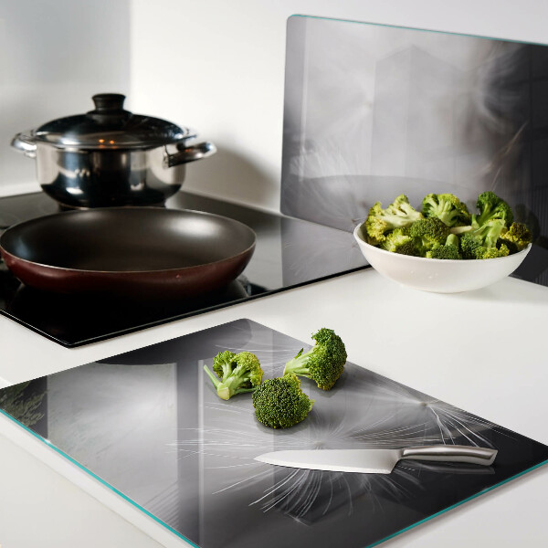Glass chopping board Fluffy dandelions against the window background